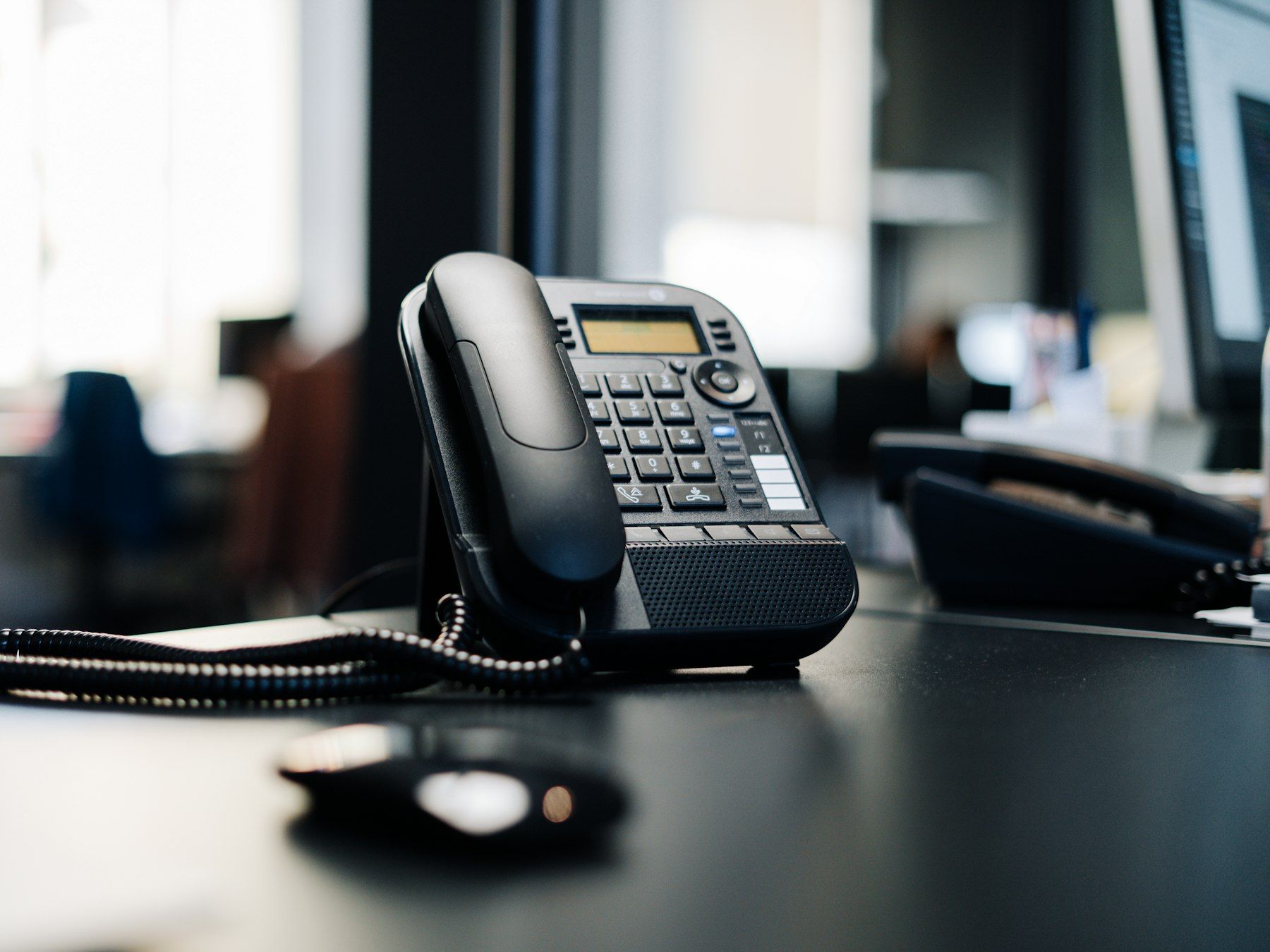 Black office desk phone in a quiet office